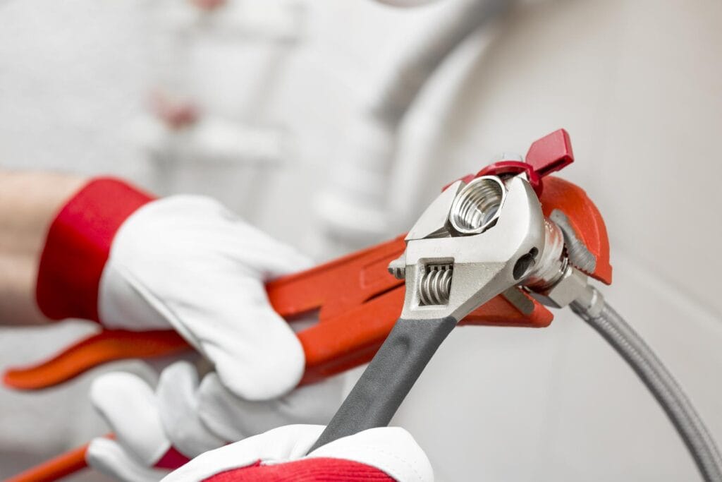Plumber holding pipe wrenches for an emergency repair in Chula Vista