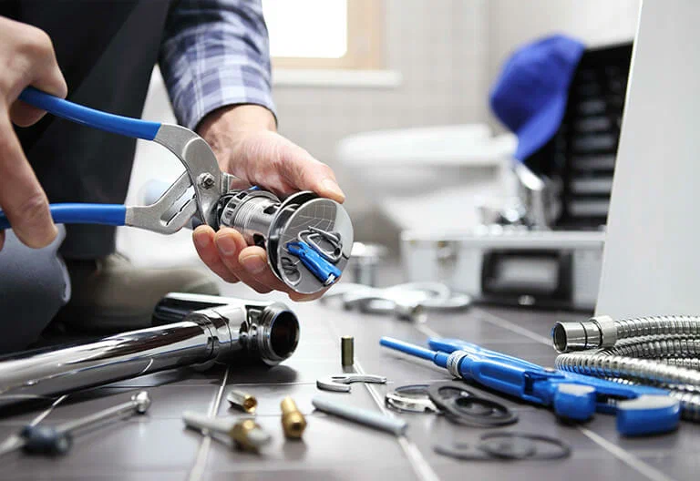 Technician repairing a plumbing fixture with professional tools in Chula Vista