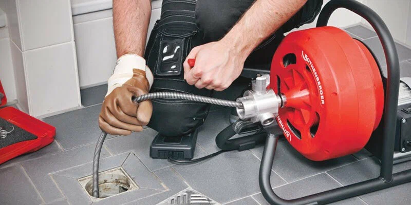 Plumber using a drain-cleaning machine in Chula Vista