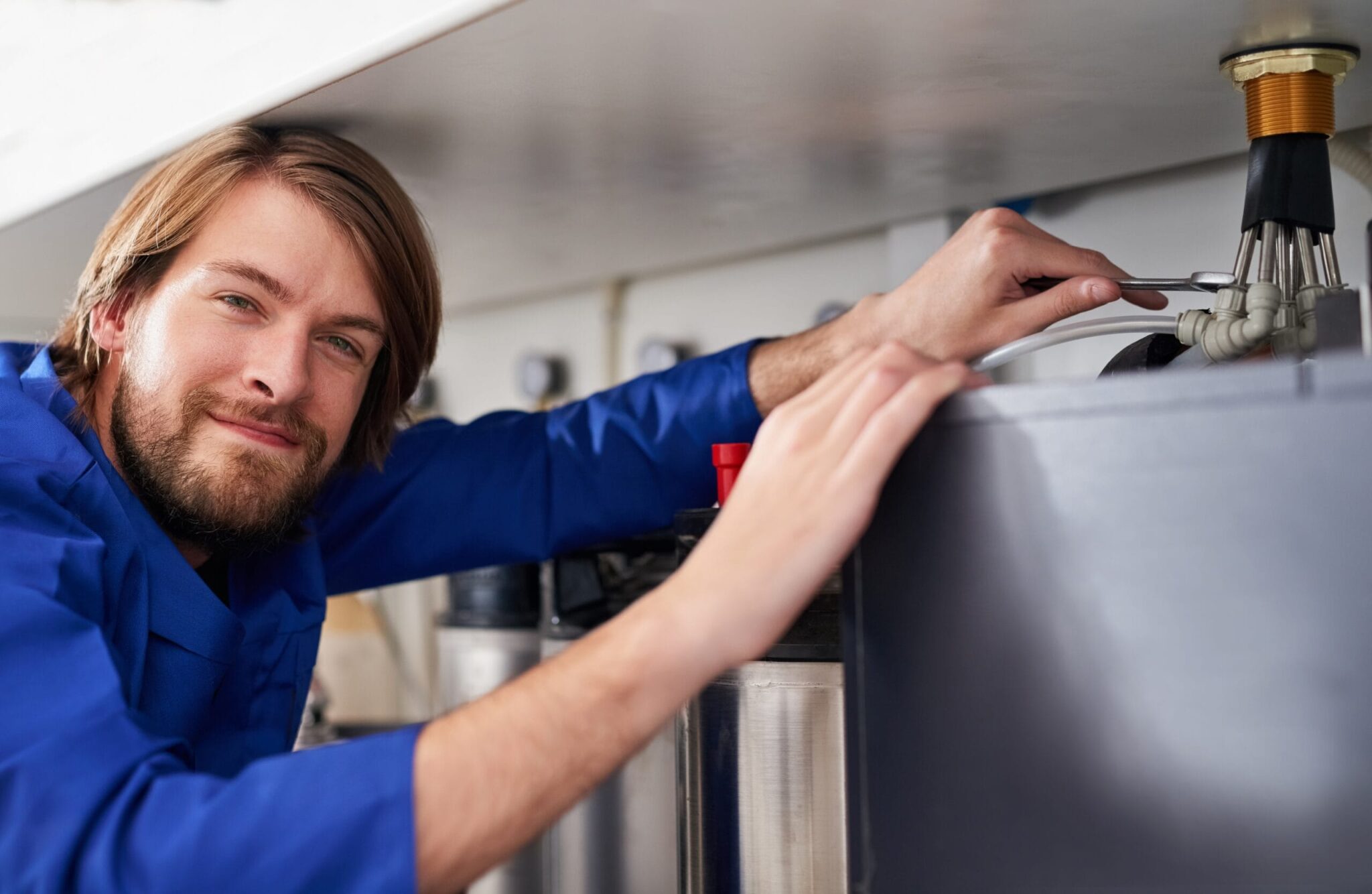 Technician servicing a residential water heater tank in Chula Vista